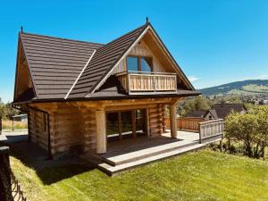 a log cabin with a porch and a deck at Cicha Ostoja in Czarny Dunajec