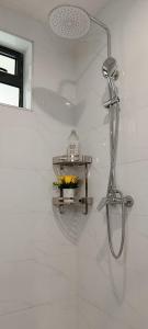 een douche in een badkamer met een plank aan de muur bij Cozy Ruaka Retreat in Ruaka