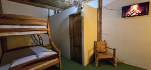 a room with two bunk beds and a tv at Hostal ElRojo Montañita in Montañita
