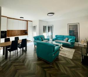 a living room with blue couches and a dining room at Tians Apartment in Prishtinë