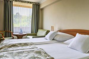 ein Hotelzimmer mit zwei Betten und einem Fenster in der Unterkunft Hotel Bartan Gdansk Seaside in Danzig