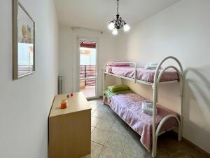 a room with two bunk beds and a table at Ros House - Grande Appartamento con Veranda & balcone in Uggiano la Chiesa