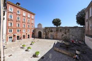 einen Innenhof mit Topfpflanzen vor einem Gebäude in der Unterkunft Sidra Heritage in Zadar