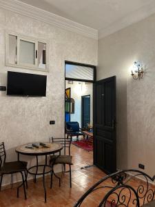 sala de estar con mesa, sillas y puerta en Dar Daroune, en Marrakech