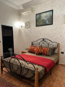 1 dormitorio con cama de metal y almohadas en Dar Daroune, en Marrakech