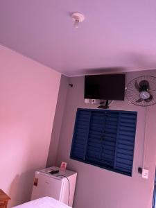 a room with a window and a television on the wall at Pousada Refúgio Encantado in Goiás