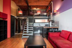 a living room with a red couch and a kitchen at Dream Aparts - Lofty Scheiblera in Łódź