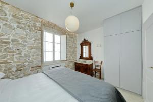 ein Schlafzimmer mit einer Steinmauer und einem großen Bett in der Unterkunft Sidra Heritage in Zadar