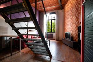 a spiral staircase in a room with a table at Dream Aparts - Lofty Scheiblera in Łódź