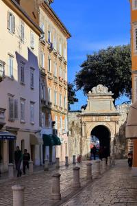 ein Gebäude mit einem Bogen in der Mitte einer Straße in der Unterkunft Sidra Heritage in Zadar
