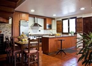 a kitchen with wooden cabinets and a table with chairs at VILLA PAQUITA Anero in Anero