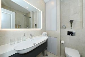 ein Badezimmer mit Waschbecken, Toilette und Spiegel in der Unterkunft Sidra Heritage in Zadar + 38 Fotos