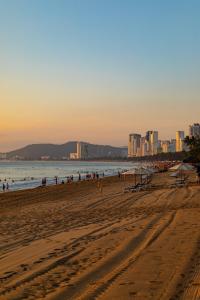 a beach with people in the water and buildings at Salou Vars Rafayel in Salou