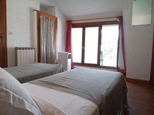 two beds in a room with a window at Chambres d'hôtes du Domaine de Cabrières in Saint-Jean-du-Gard