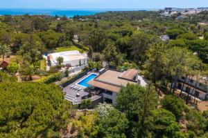 an aerial view of a house with a swimming pool and the ocean at Balaia Retreat - Nature & Beach in Olhos de Água