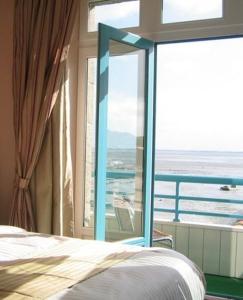 a bedroom with a bed and a large window at La Mere Champlain in Cancale