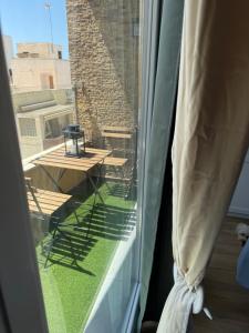 a window with a view of a balcony with a table at Apartamento centro 3 habitaciones in Almería