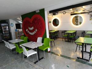 a restaurant with tables and a heart on the wall at Hotel Hierbabuena y Restaurante in Pasto