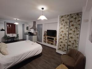 a bedroom with a white bed and a living room at Studio zen in Bastia