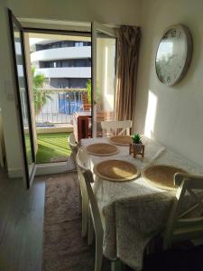 a dining room with a table and chairs and a clock at Studio centre port,piscine et parking sous terrain in Cap d'Agde