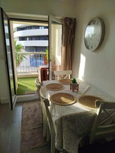 a dining room with a table and chairs and a clock at Studio centre port,piscine et parking sous terrain in Cap d'Agde +16 photos