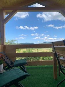 a porch with a bench and a view of a field at Oaza mira 3 in Kokin Brod +8 photos