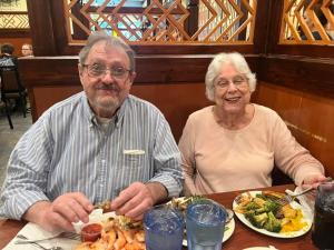 um homem e uma mulher sentados numa mesa com um prato de comida em count classiq em Pretoria