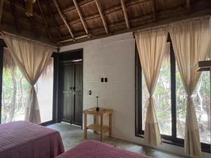 ein Schlafzimmer mit zwei Betten und großen Fenstern in der Unterkunft Sak in Tulum