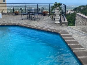 a swimming pool with a table and chairs on a patio at City Scape Serenity Kingston in Tunbridge