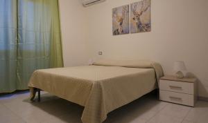 Quartu Sant'ElenaにあるSea View Apartmentのベッドとナイトスタンドのある小さな寝室