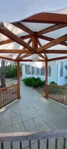 a wooden pergola on a patio in front of a house at ДАЧА на Студенческой in Karolino-Buhaz