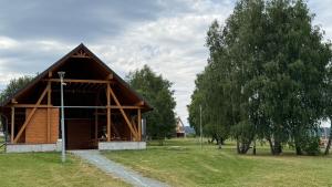 a small cabin in a field with a tree at Dom z widokiem in Miszkowice