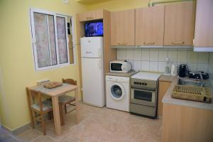 a kitchen with a refrigerator and a table and a microwave at Dorita in Íasmos