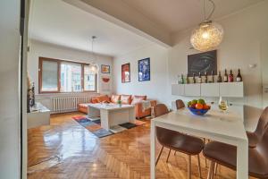 a living room with a table and a couch at Main Street Sunshine 2 KING Bdr in Sofia