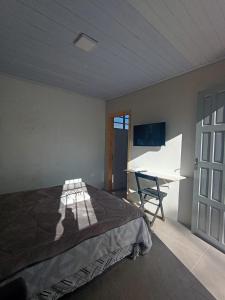 a bedroom with a bed and a desk in it at New hotel in Alegrete
