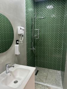 a bathroom with a sink and a shower with green tile at HG Villa Gabala in Gabala