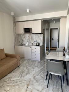 Una cocina y una sala de estar con una mesa y un sofá. en VistaRest Gudauri Ski Resort - by VistaRest Escapes & Stays, en Gudauri