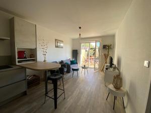 a kitchen and living room with a table and chairs at Sea Breeze Gujan-Mestras in La Celle-sous-Gouzon