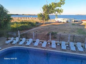a group of chairs and a swimming pool next to the ocean at Студия 310 и 312 на първа линия in Chernomorets
