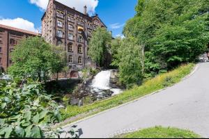 a building with a waterfall in front of a road at Charming Duplex near the beautiful Akerselva river in Oslo