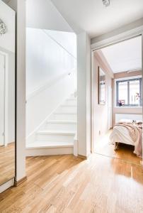 a bedroom with white walls and a staircase and a bed at Charming Duplex near the beautiful Akerselva river in Oslo