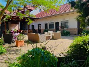 a patio of a house with chairs and tables at Guest House Romantika Panzio in Gyula