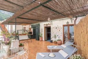 a patio with tables and chairs and a wooden ceiling at Casa Vivì in Positano