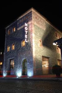 a stone building with a sign on it at night at Hotel Çarshia e Jupave in Gjakove