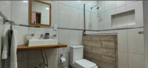 a bathroom with a toilet and a sink and a mirror at Casa de Campo El Molino in Federación
