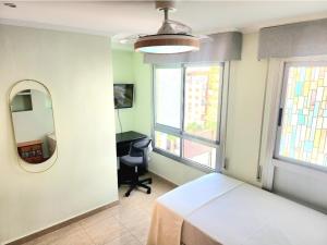 Un dormitorio con una cama, un escritorio y un espejo. en Room Lidón Center 2, en Castellón de la Plana
