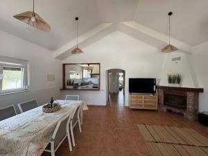 a living room with a table and a fireplace at Casa dos Sobreiros in Palmela