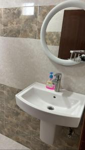 a white sink in a bathroom with a mirror at فندق ثمريت in Thamarīt