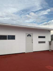 a white garage with a door and a red driveway at Nice apartment in a central area in Chihuahua
