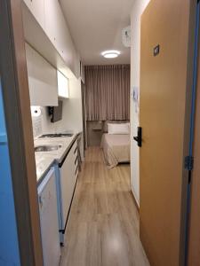 a small kitchen with a sink and a room at Studio Smart lindo e funcional in Salvador